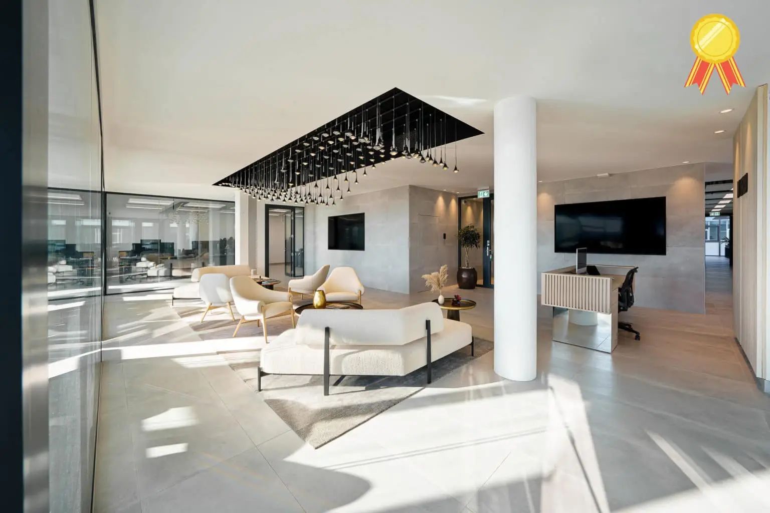 Espace d'accueil de bureaux modernes avec salon d'attente, mobilier design, suspension lumineuse contemporaine et grandes cloisons vitrées.