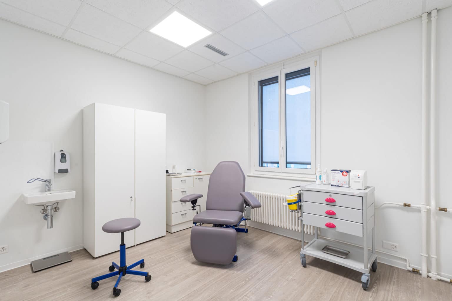 Salle de prélèvement moderne avec fauteuil médical, mobilier de soins et espace lumineux dédié aux analyses.