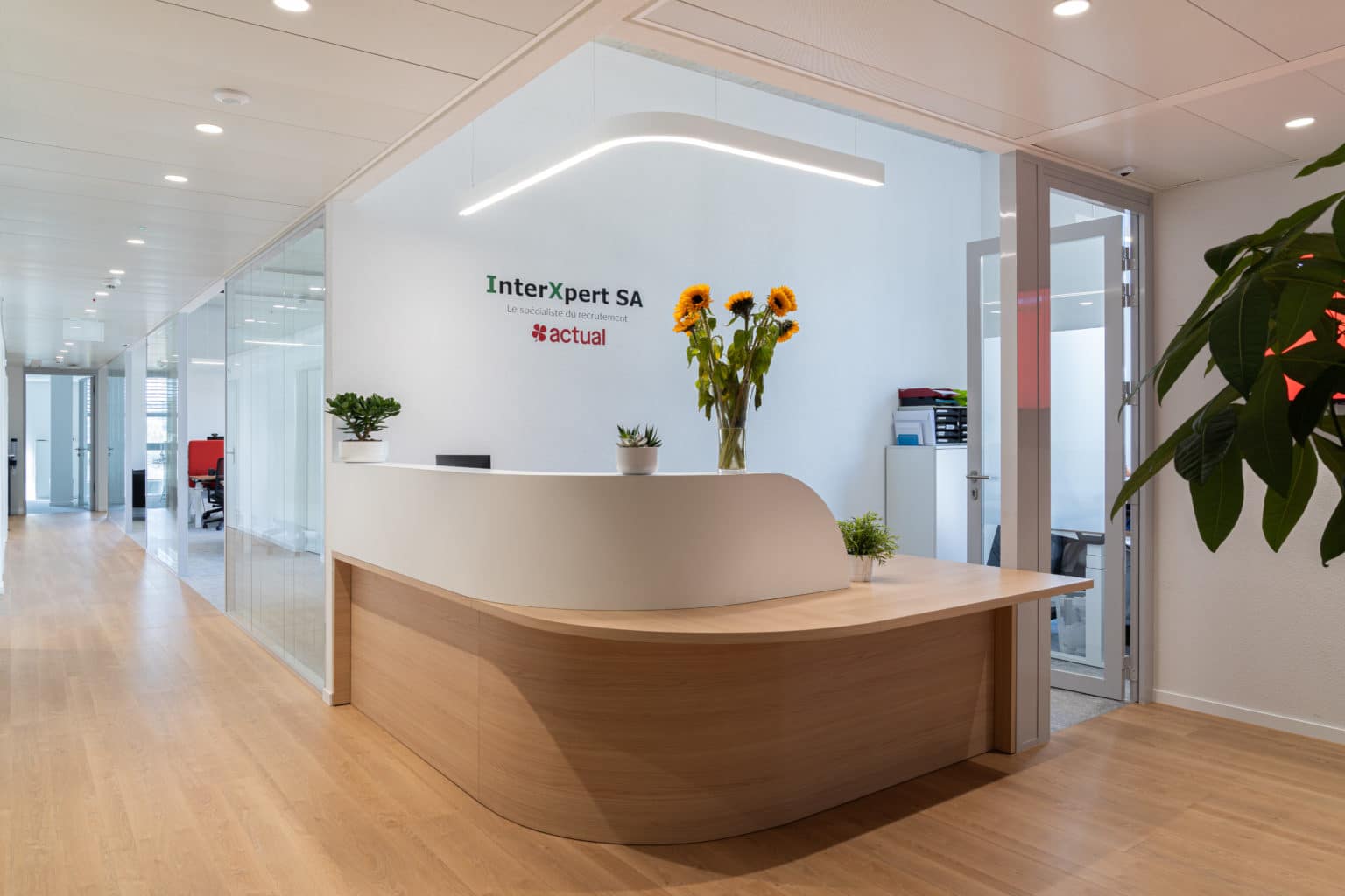 Espace d'accueil du projet Actual avec banque de réception et bureaux contemporains à Genève.