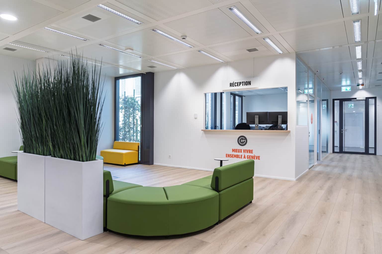 Banque d'accueil moderne avec espace de réception, signalétique et zone d'attente.