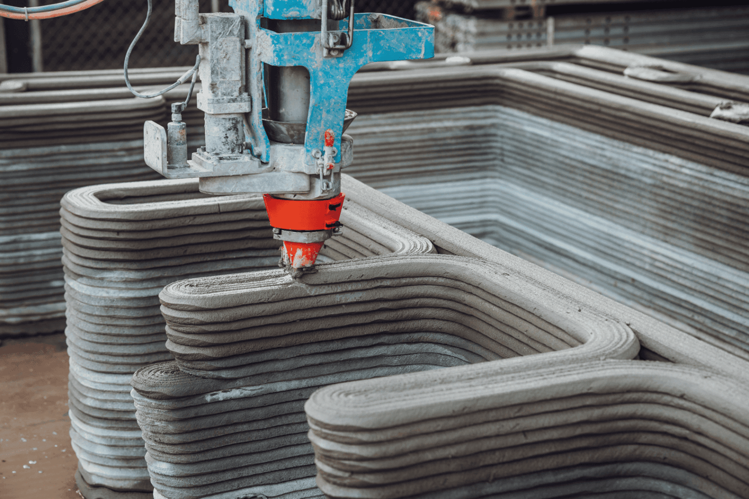 Bras robotisé déposant des couches successives de béton, pionnier de l'impression 3d dans la construction.