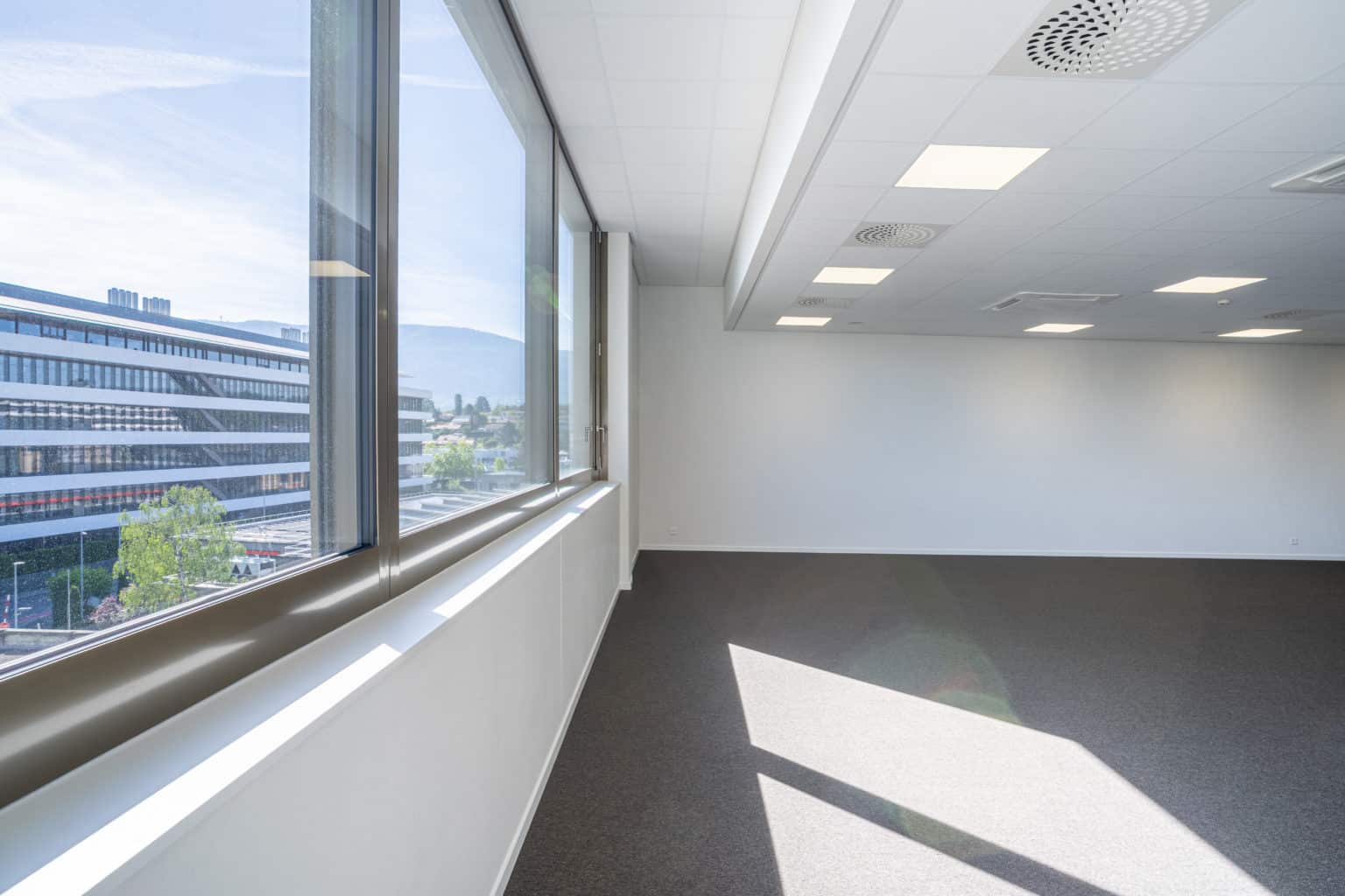 Espace de travail bénéficiant d'une importante lumière naturelle grâce aux grandes fenêtres.