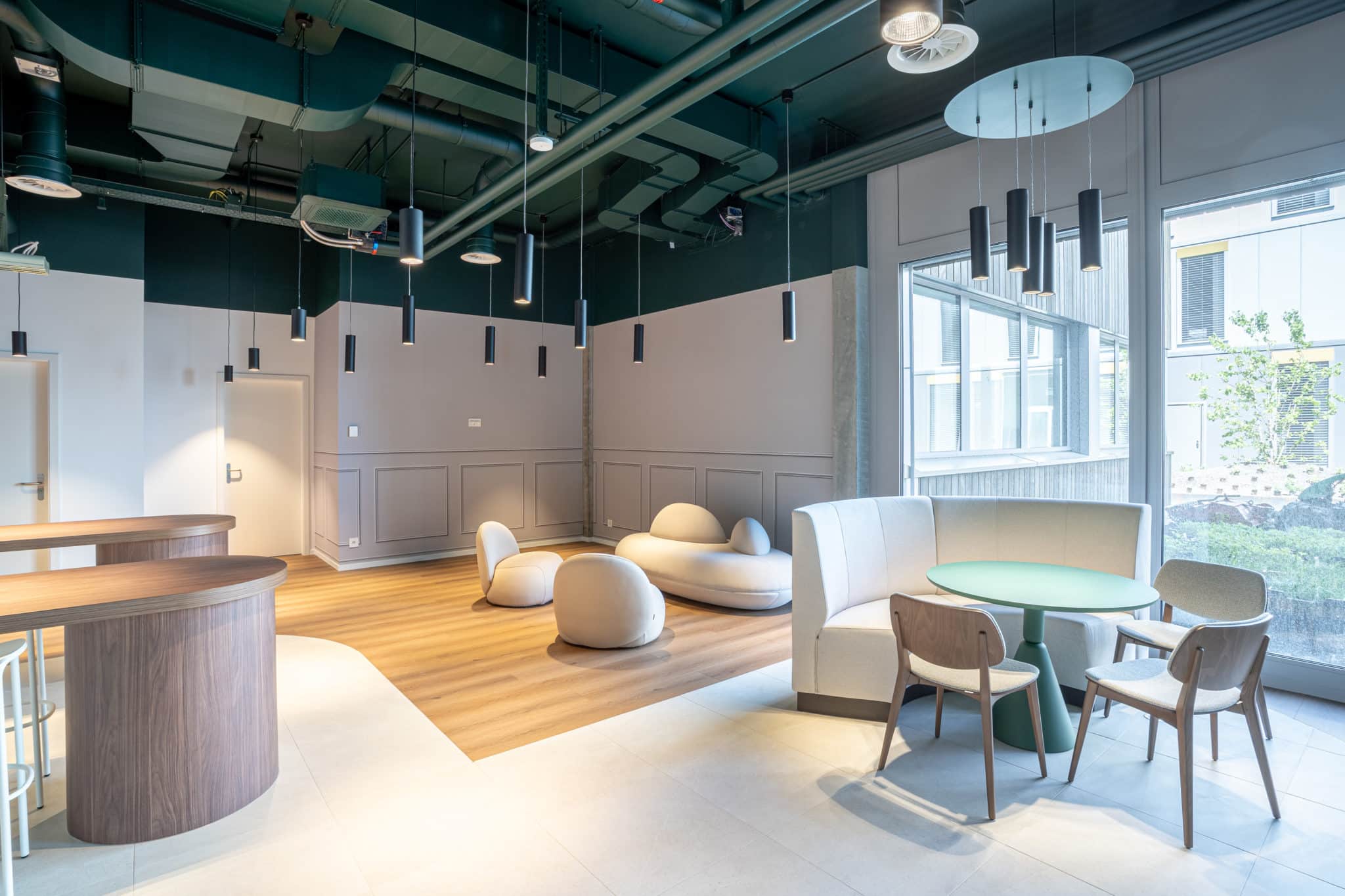 Aménagement d'un hall d'entrée professionnel à Genève avec espace lounge, mobilier design et lumière naturelle.