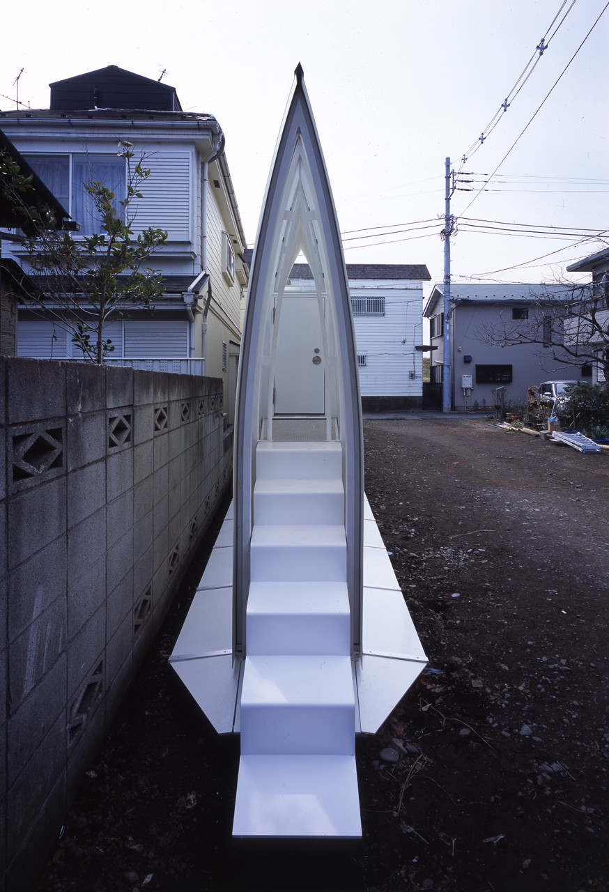 Entrée étroite et profilée en ogive d'une habitation minimale et compacte, caractéristique de la micro-architecture japonaise.