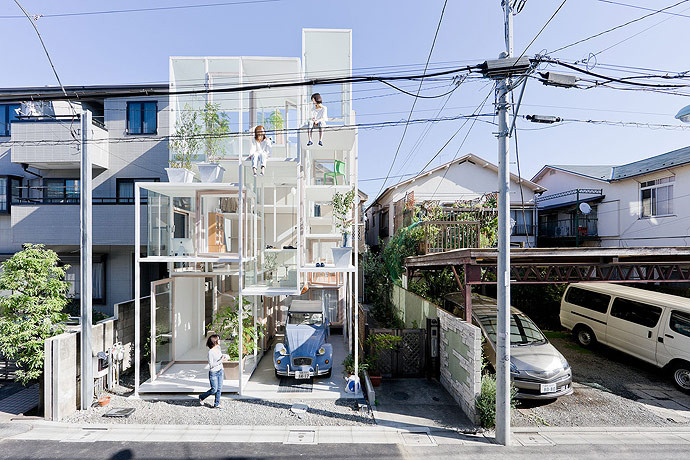 Façade entièrement vitrée sur plusieurs niveaux d'une maison d'architecte japonaise avec structure métallique fine et voiture ancienne.