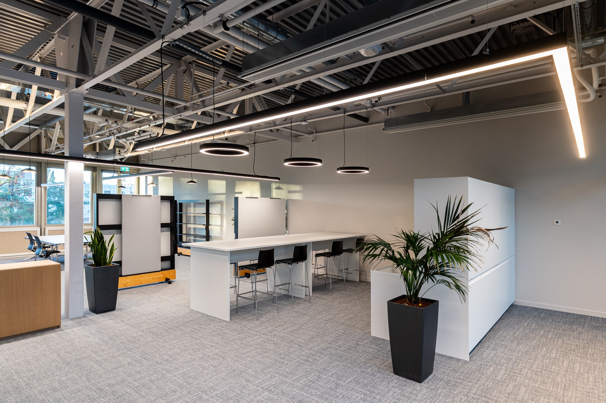 Aménagement tertiaire aux volumes généreux, structuré par le mobilier et les cloisons modulaires.